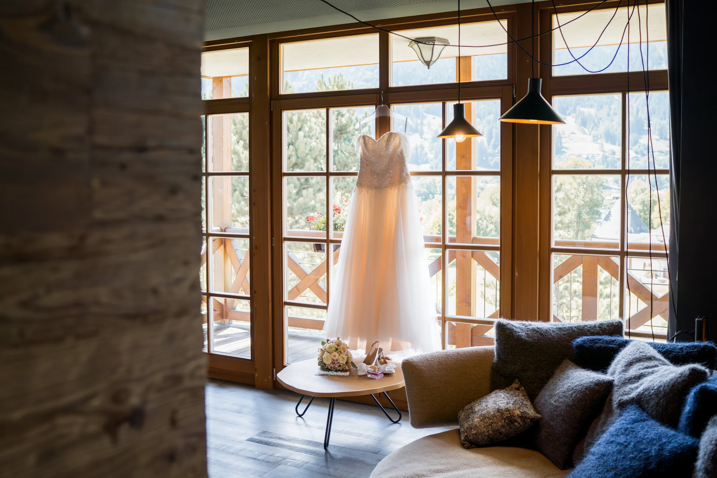 Brautkleid vor den Fenstern mit Blick auf die Tiroler Berge