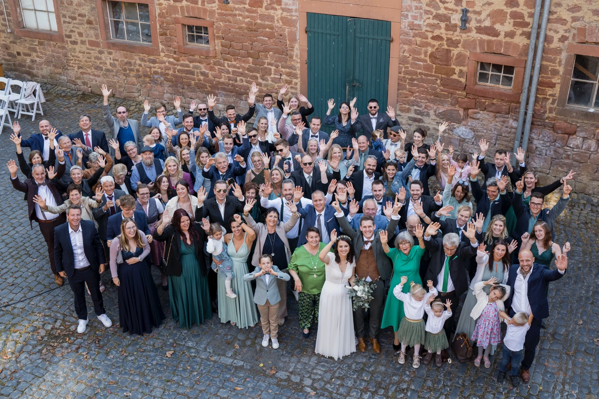 Gruppenfoto mit Sabrina, Tobias und all ihren Hochzeitsgästen im Hühnerhof