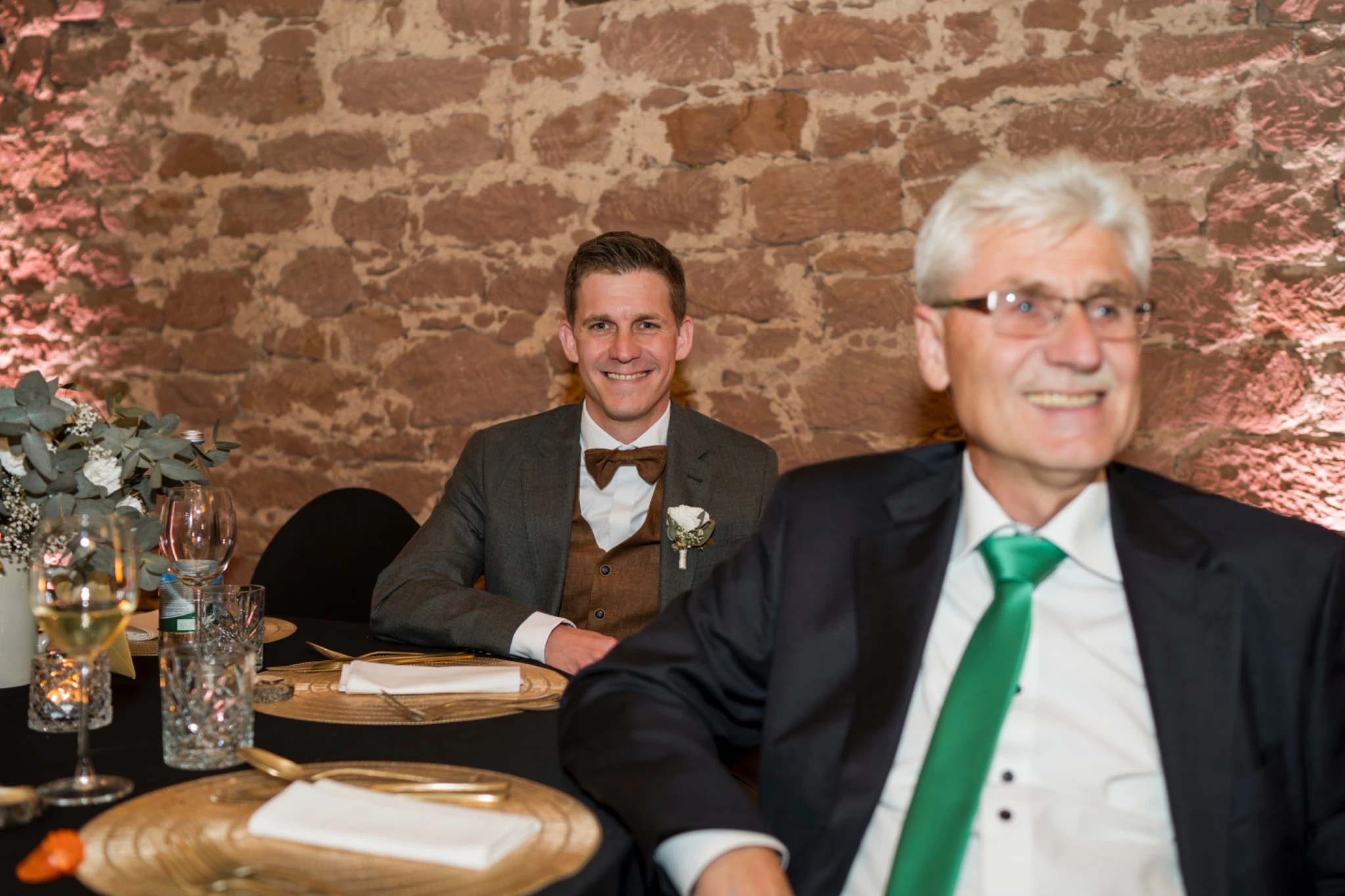 Tobias sitzt mit seinem Vater am Tisch während der Feier