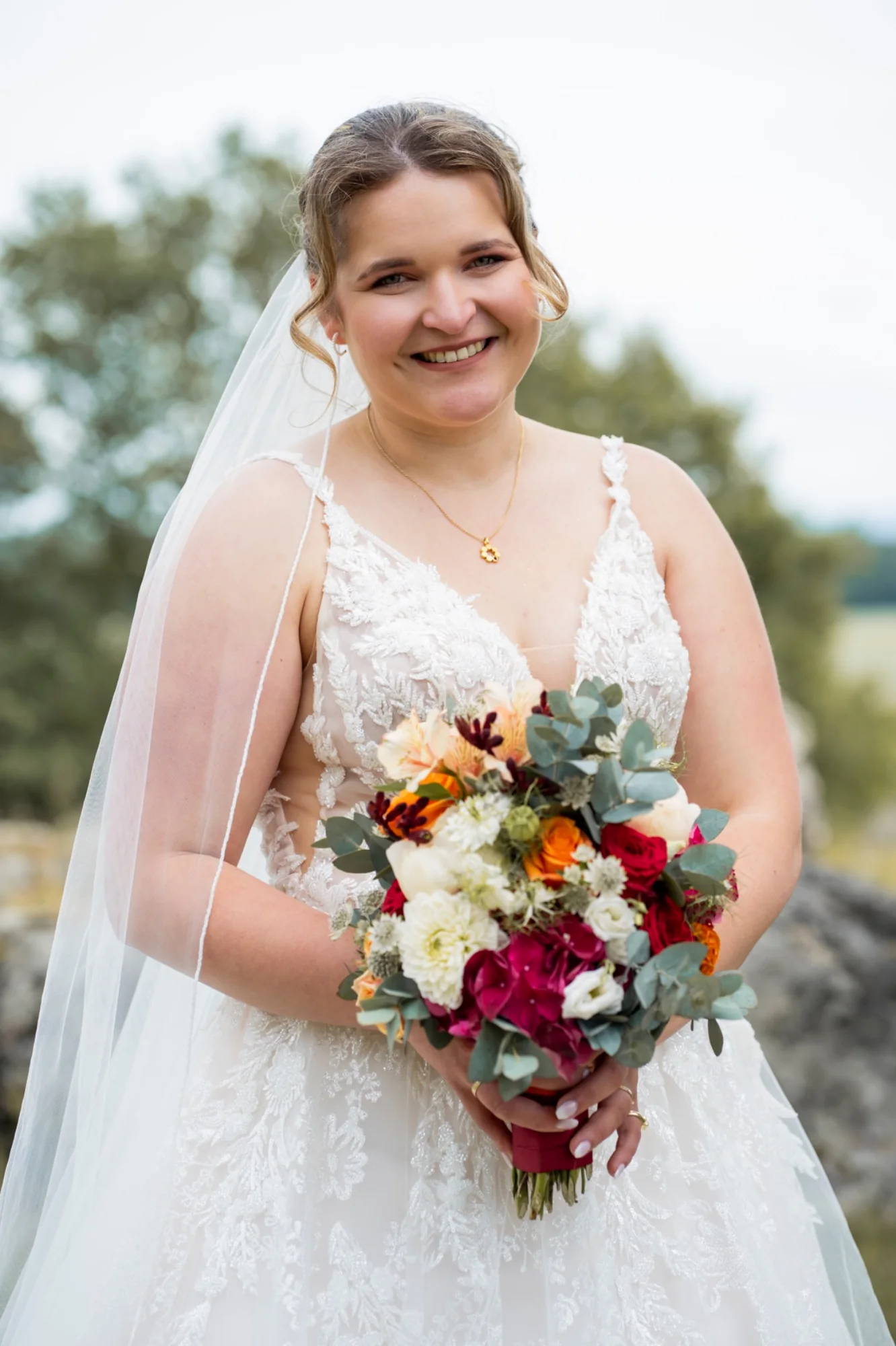 Natürliches Brautportrait von Franziska mit ihrem farbenfrohen Blumenstrauß
